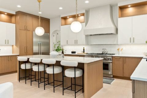 Bright and airy kitchen interior showing bar stools at the island.