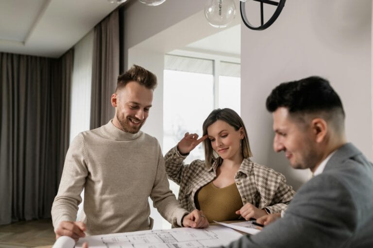 Couple working with their architect going over blueprint plans for their new home.
